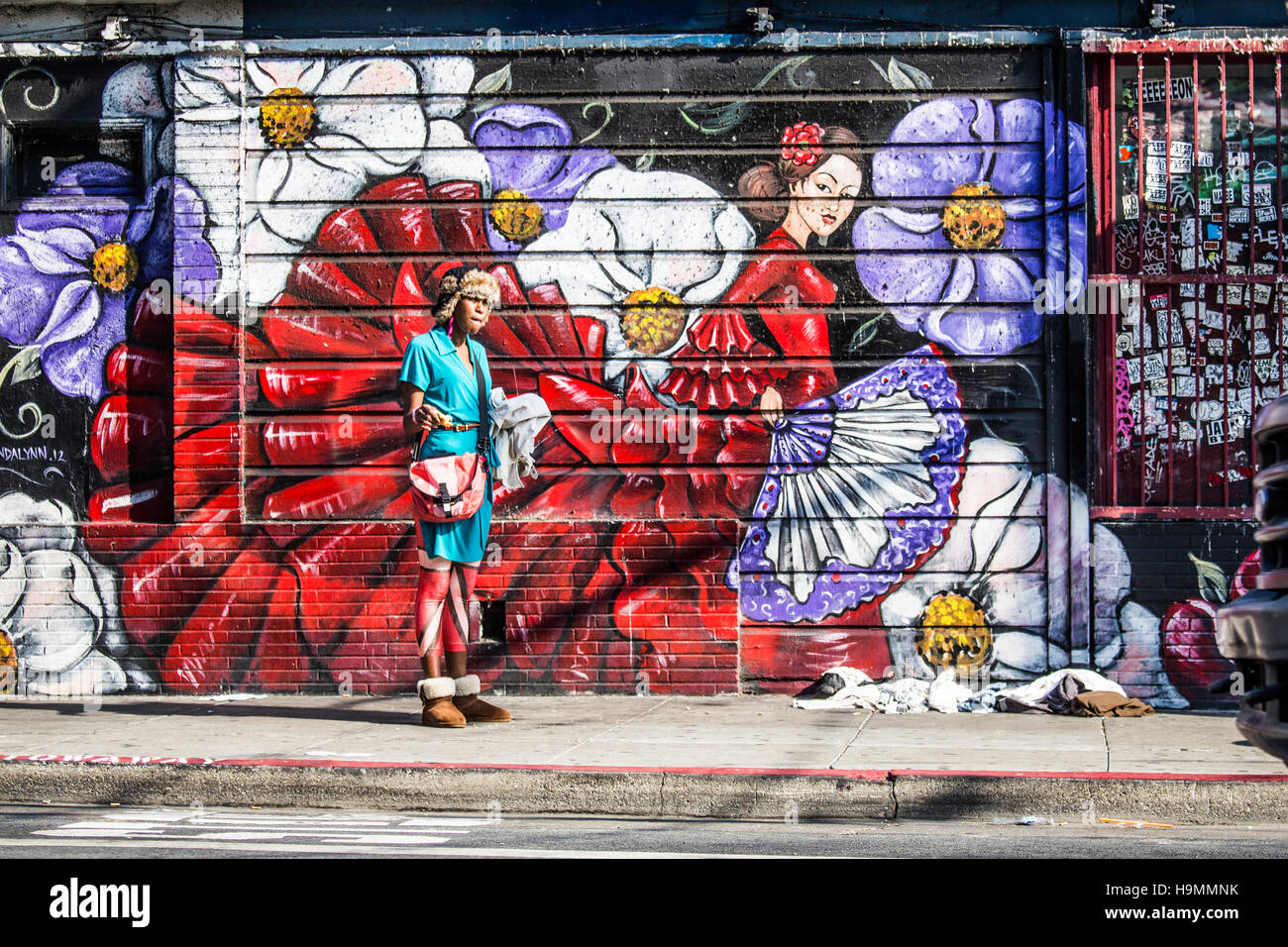 Mujer sin hogar en frente de arte callejero en la misión, San Francisco, CA. Foto de stock