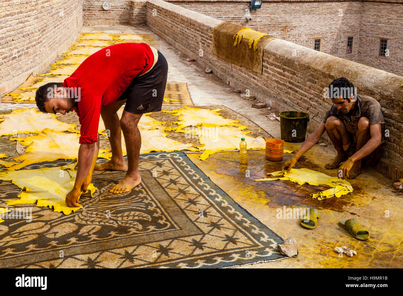 Dos hombres que trabajaban en una pequeña curtiduría en la Medina de Fez el Bali, Fez, Marruecos Foto de stock