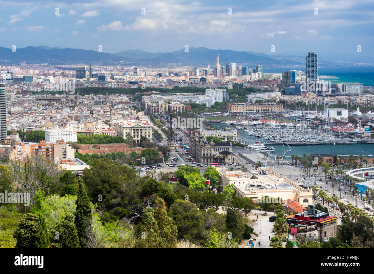 Vista del centro de la ciudad, frente al mar, y el pequeño barco del puerto de Barcelona, Cataluña, España. Foto de stock