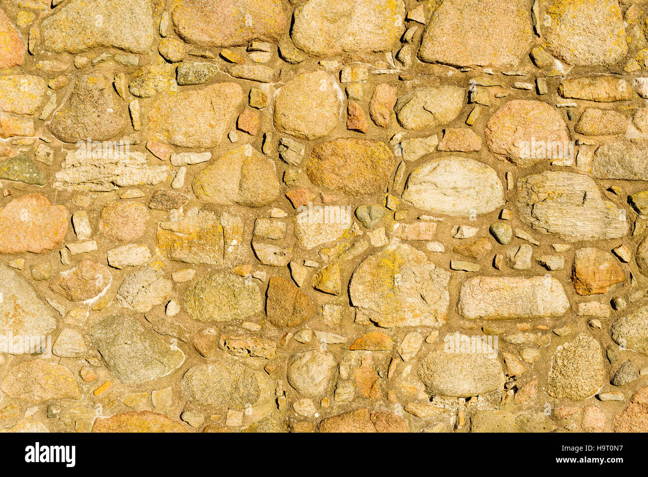 Muro de Piedra de fondo con cantos rodados y concreta. Foto de stock