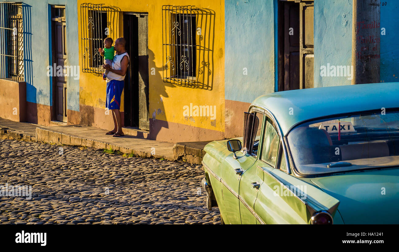 Los cubanos con oldtimer taxi en Trinidad Foto de stock