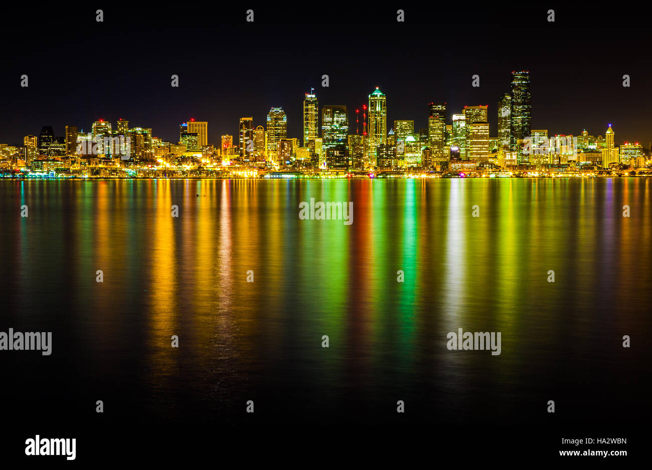 El horizonte de Seattle por la noche como se ve desde el Alki. Una larga exposición permite a Puget Sound, empaparse de los colores de la ciudad por la noche. Foto de stock