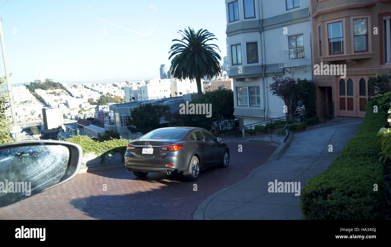 SAN FRANCISCO, EEUU - octubre 5th, 2014: vehículos conducir cuesta abajo en Lombard Street, el monumento más famoso y crookedest en el mundo Foto de stock