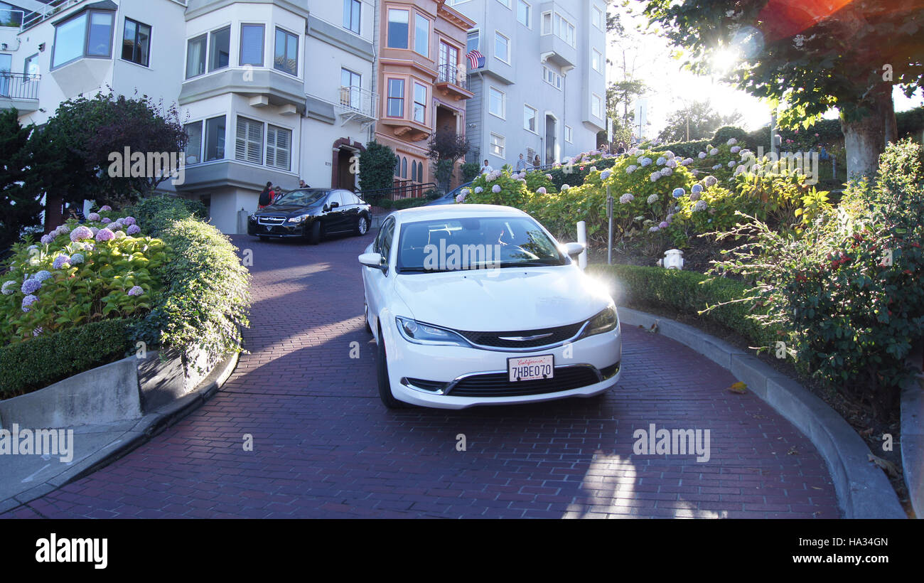 SAN FRANCISCO, EEUU - octubre 5th, 2014: vehículos conducir cuesta abajo en Lombard Street, el monumento más famoso y crookedest en el mundo Foto de stock