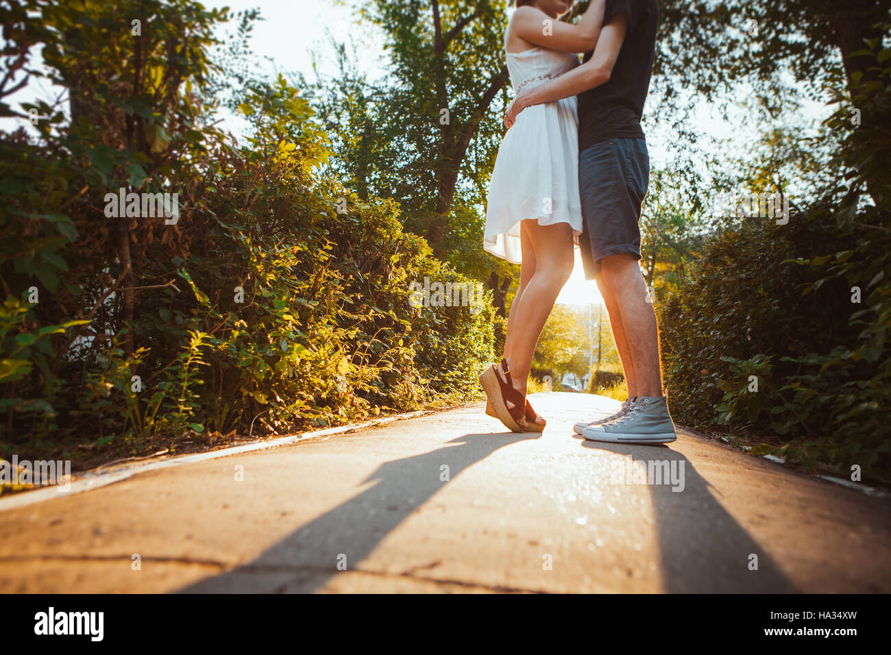 Piernas chico y chica abrazando sobre un fondo de parque. Foto de stock