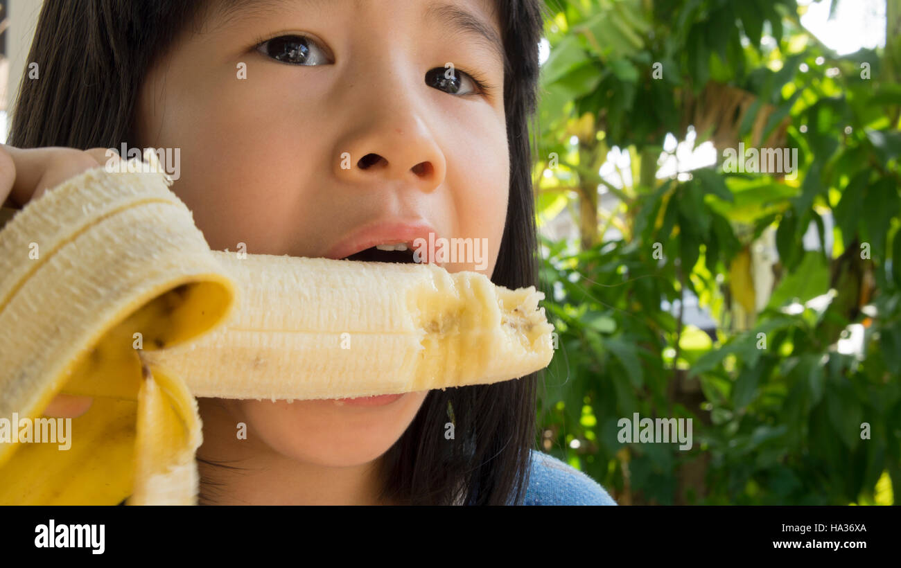 Cute little girl eating banana fotografías e imágenes de alta