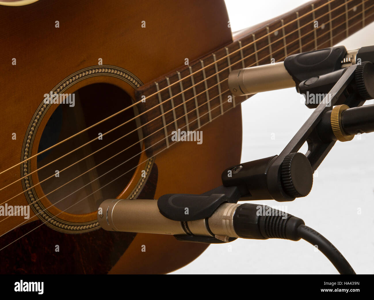 La grabación de una guitarra con un par de micrófonos de condensador de instrumento, uno en el cuello, la otra hacia el puente Foto de stock