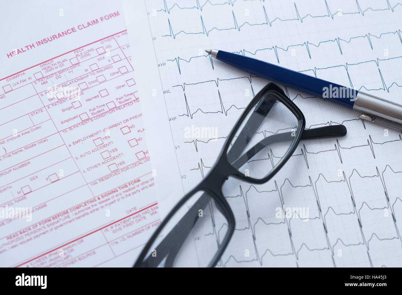 Formulario de reclamación de seguros de salud con bolígrafo y gafas Foto de stock