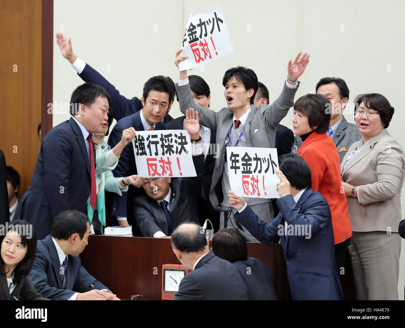 Tokio, Japón. 25 Nov, 2016. Los legisladores de la oposición se apresuran a presidente Hideki Niwa y mostrar pancartas "oponerse por la fuerza a la aprobación del proyecto de ley' en la salud, trabajo y Welfarre sesión del Comité de la Cámara Baja de la Dieta Nacional en Tokio el viernes, 25 de noviembre de 2016. Los partidos de la coalición gobernante promulgó la ley de reforma de pensiones del gobierno durante el período de sesiones del Comité, mientras que los miembros de los partidos de oposición en contra de la protesta obligó a la aprobación del proyecto de ley. © Yoshio Tsunoda/AFLO/Alamy Live News Foto de stock