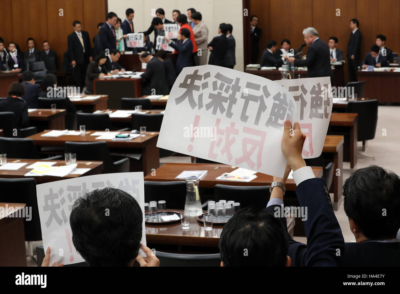 Tokio, Japón. 25 Nov, 2016. Los legisladores de la oposición se apresuran a presidente Hideki Niwa y mostrar pancartas "oponerse por la fuerza a la aprobación del proyecto de ley' en la salud, trabajo y Welfarre sesión del Comité de la Cámara Baja de la Dieta Nacional en Tokio el viernes, 25 de noviembre de 2016. Los partidos de la coalición gobernante promulgó la ley de reforma de pensiones del gobierno durante el período de sesiones del Comité, mientras que los miembros de los partidos de oposición en contra de la protesta obligó a la aprobación del proyecto de ley. © Yoshio Tsunoda/AFLO/Alamy Live News Foto de stock