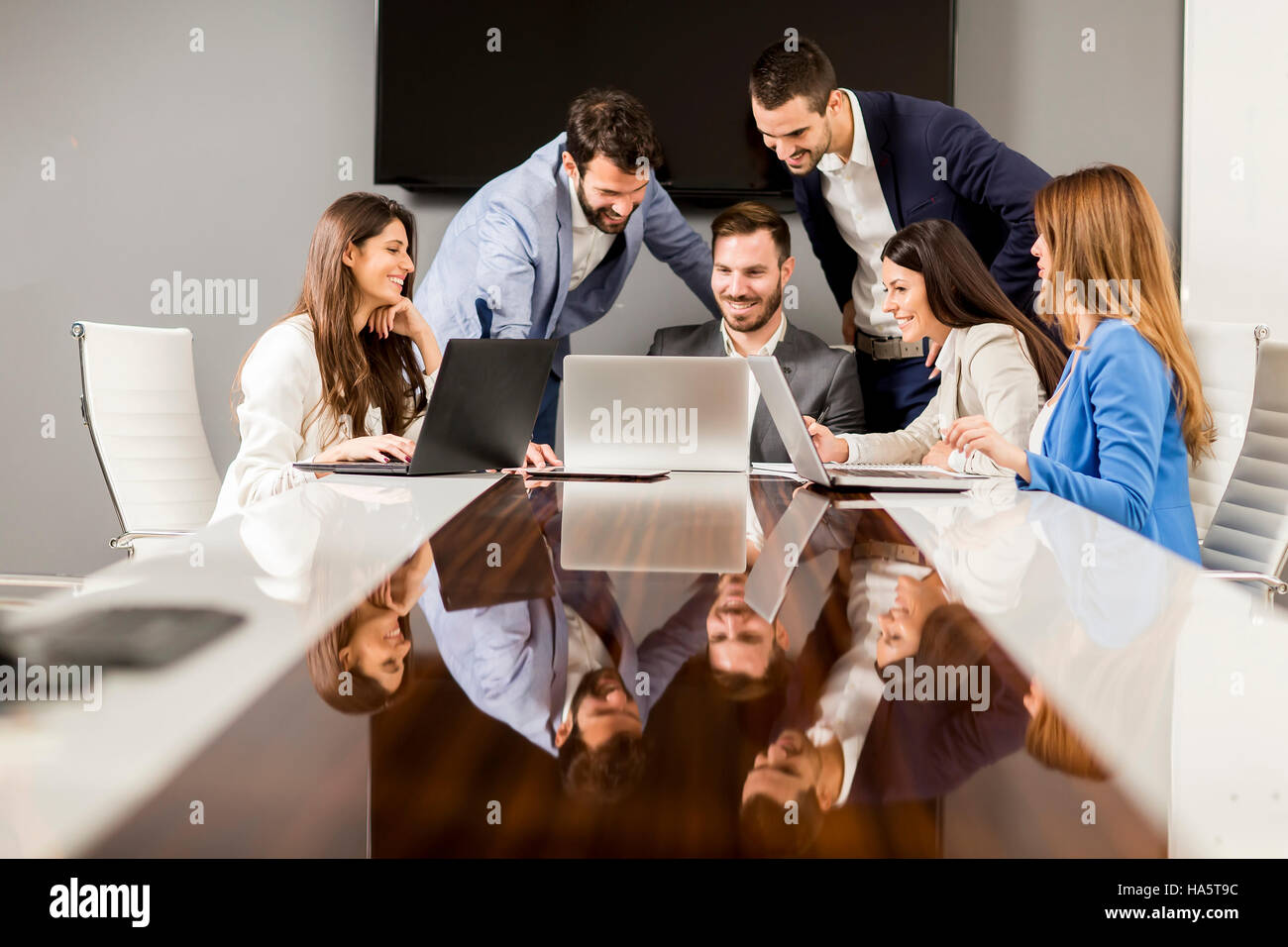 Jóvenes colegas sentados en reunión de negocios en la oficina moderna Foto de stock