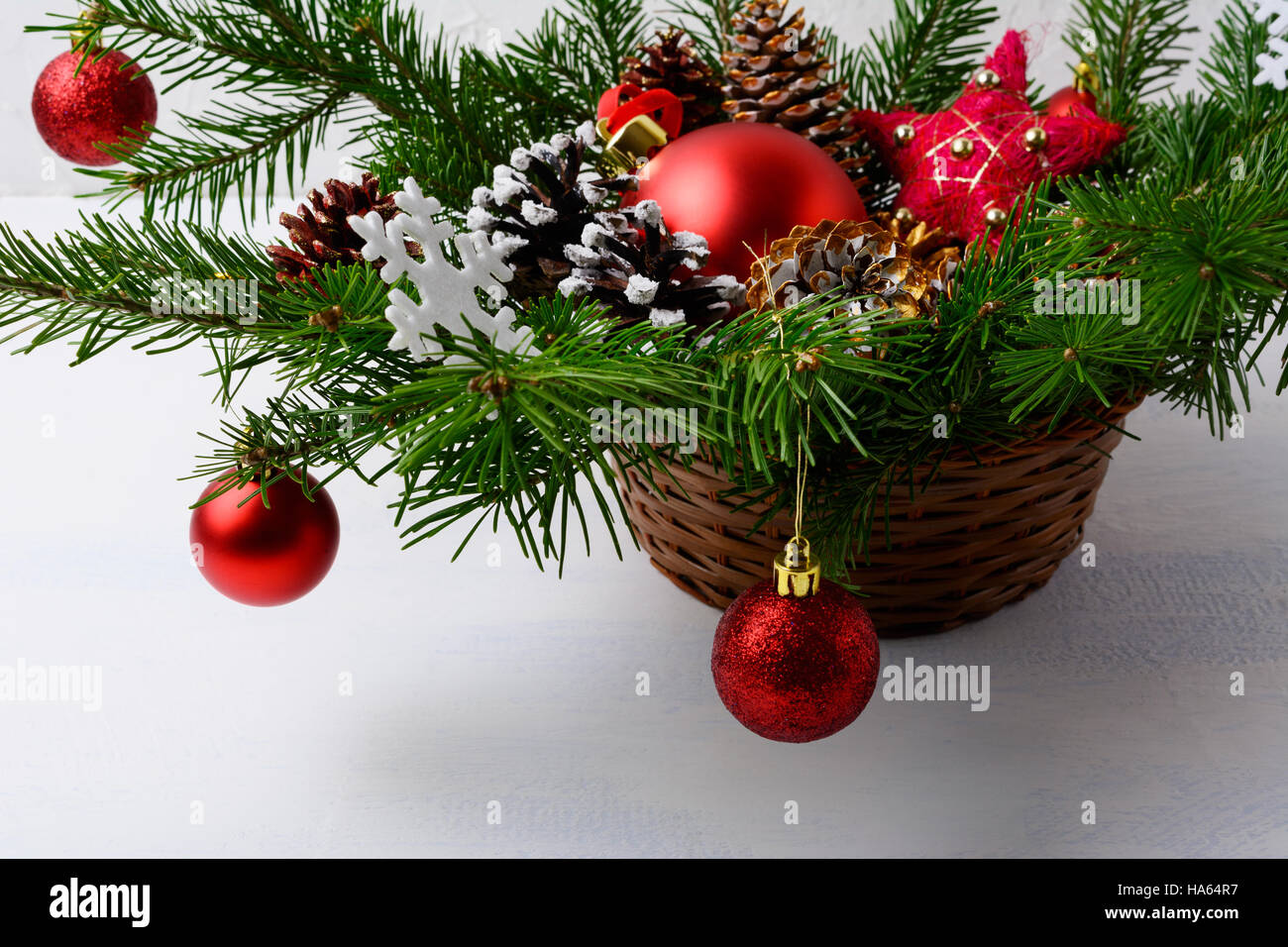 Adornos de Navidad rojo y decorada con nieve pine cone mesa de centro.  Fondo de navidad con arreglo en canasta de mimbre Fotografía de stock -  Alamy