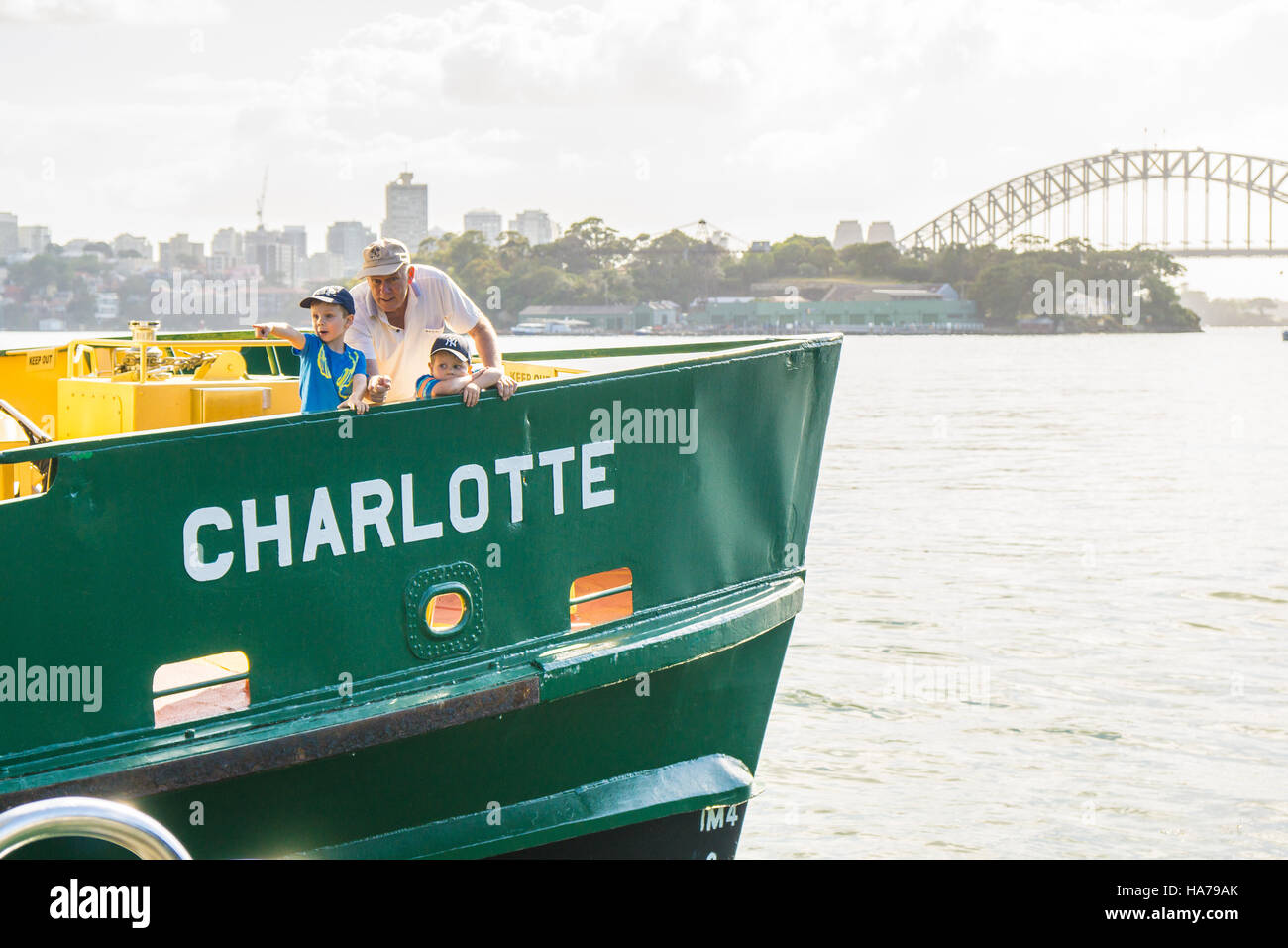 Un abuelo o papá mayores con dos niños en un ferry en el puerto de Sydney Foto de stock