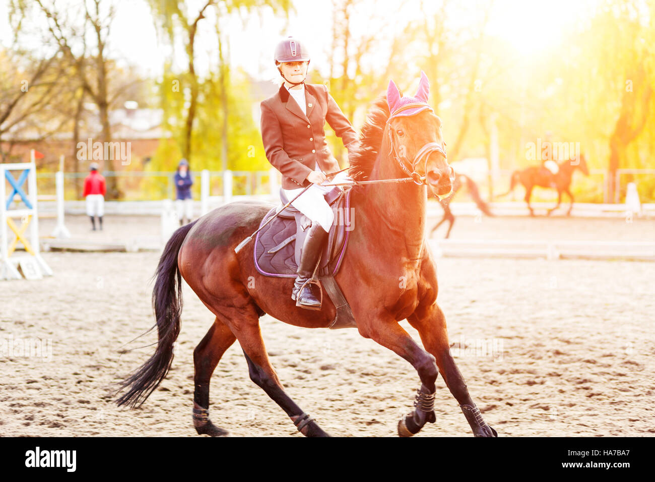 Mujer joven jinete en caballo en la competencia. Antecedentes del deporte ecuestre Foto de stock