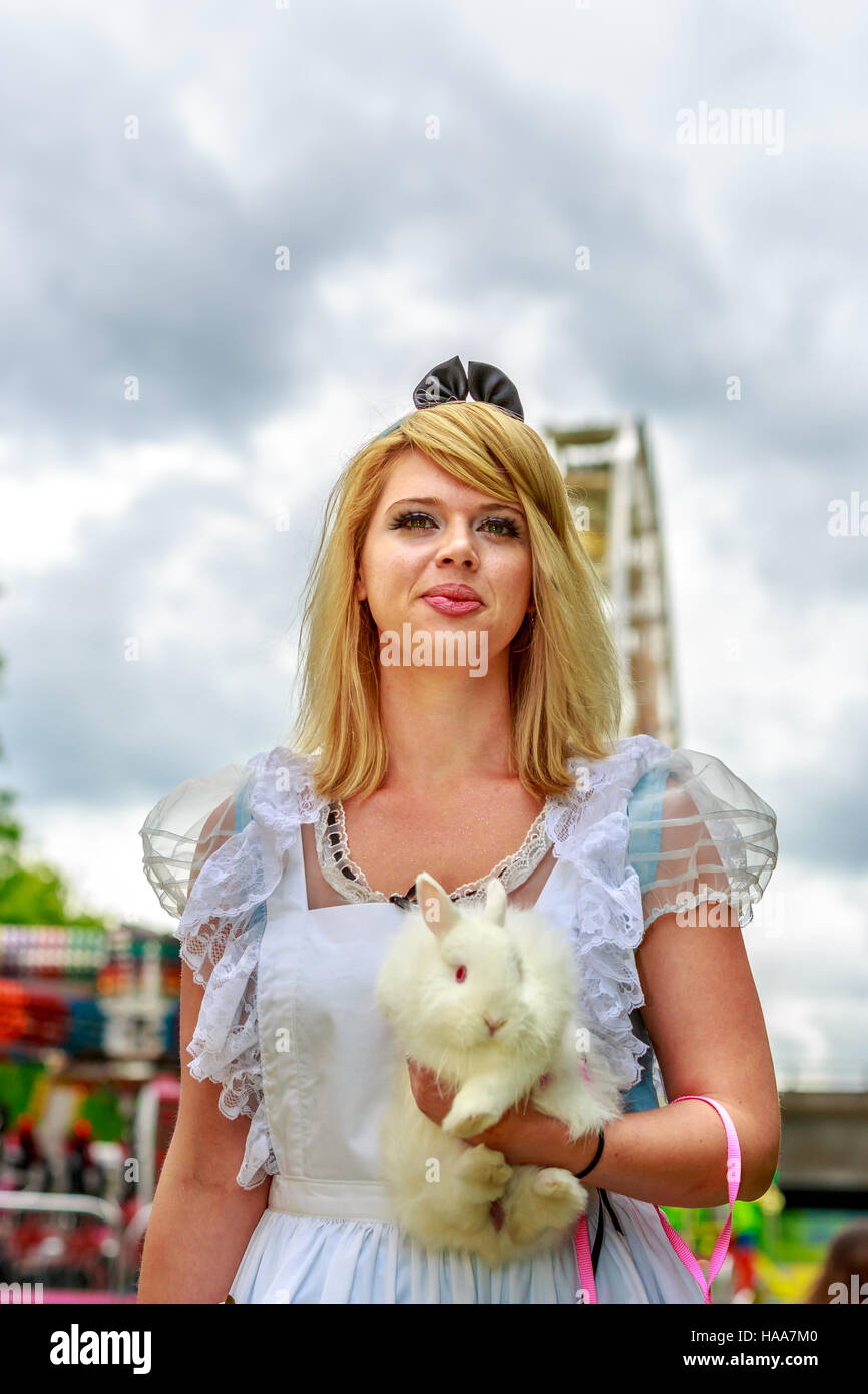 Atractivo modelo femenino en Alice traje, con el conejo blanco, en el país de las maravillas. Foto de stock