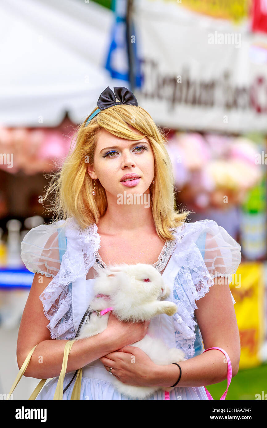 Atractivo modelo femenino en Alice traje, con el conejo blanco, en el país de las maravillas. Foto de stock