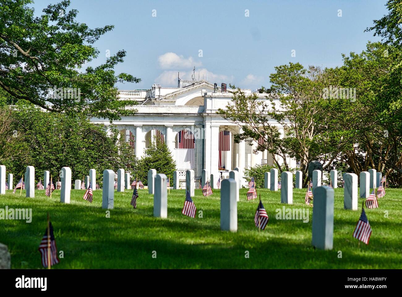 Lápidas con banderas americanas cerca de anfiteatro conmemorativo en el Cementerio Nacional de Arlington Arlington, Virginia, EE.UU. Foto de stock