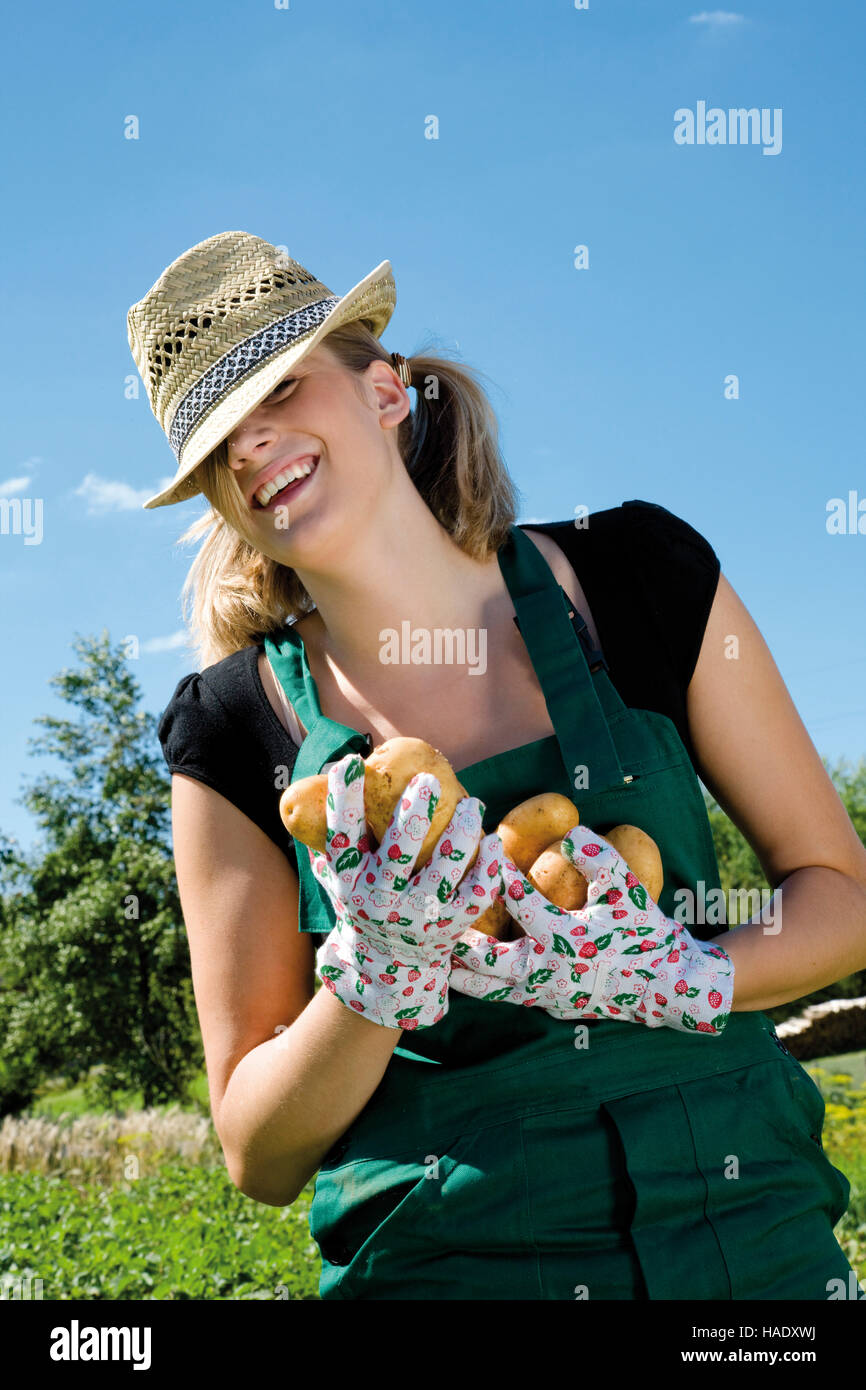 Mujer joven cosechar patatas Foto de stock
