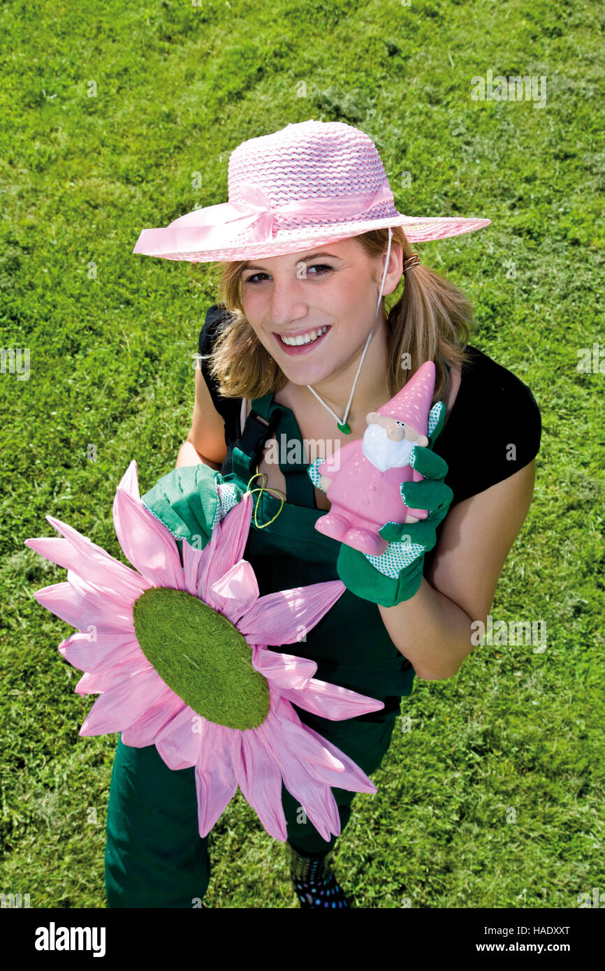 Jardinero hembra con flor de papel y jardín gnome Foto de stock