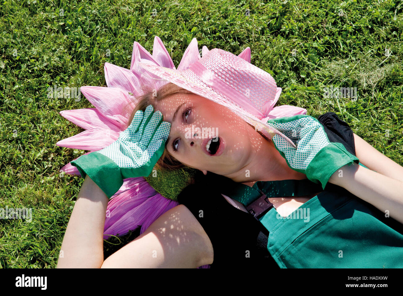 Jardinero hembra con flor de papel y sombrero de paja en la luz del sol Foto de stock