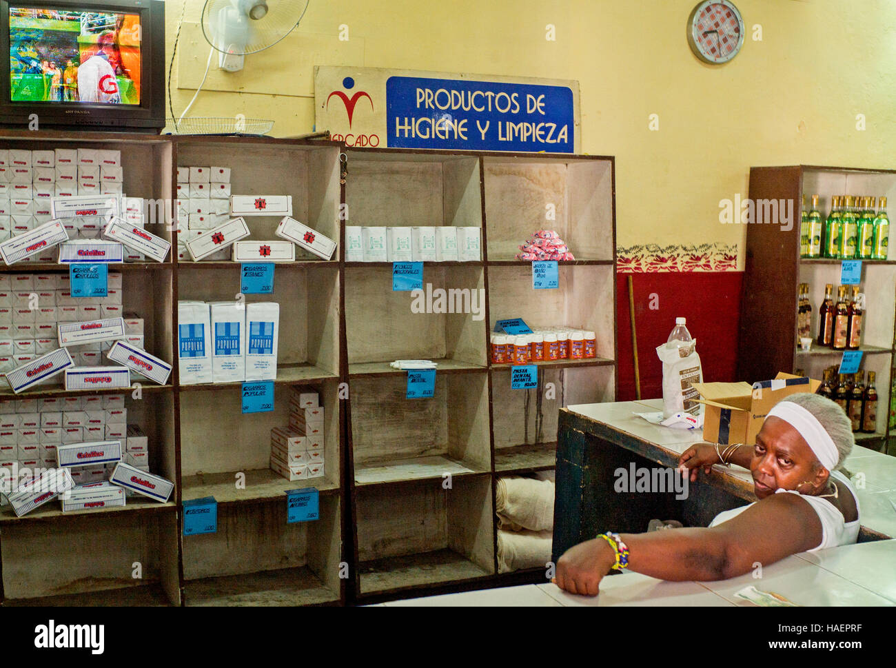 La Habana, Cuba,tienda de alimentos del gobierno,mujer dependienta viendo televisión 'productos de higiene y limpieza" Foto de stock
