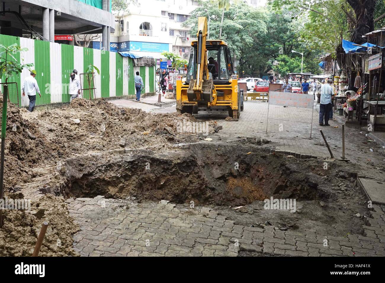 La superficie de la carretera se derrumba en Matunga, en Mumbai, India, el 24 de septiembre de 2016, para crear un sumidero tras una cueva en Foto de stock