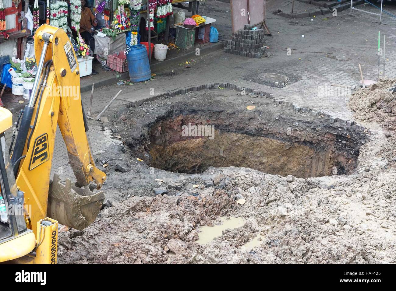 La superficie de la carretera se derrumba en Matunga, en Mumbai, India, el 24 de septiembre de 2016, para crear un sumidero tras una cueva en Foto de stock