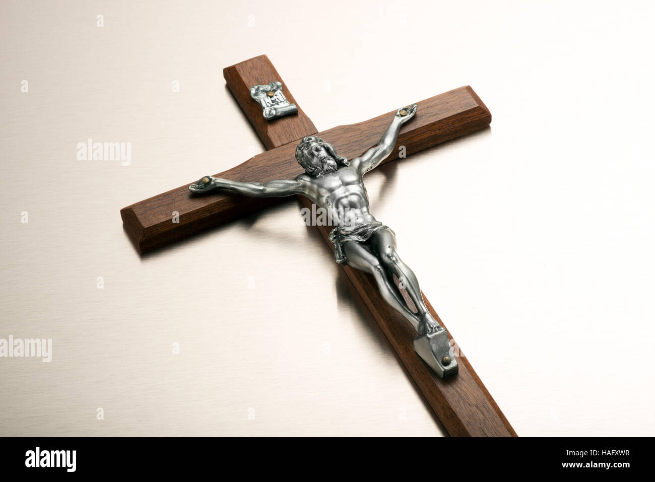 Metal plateado la figura de Cristo crucificado en un crucifijo de madera visto bajo el ángulo blanco con espacio de copia para la Pascua o concepciones religiosas Foto de stock