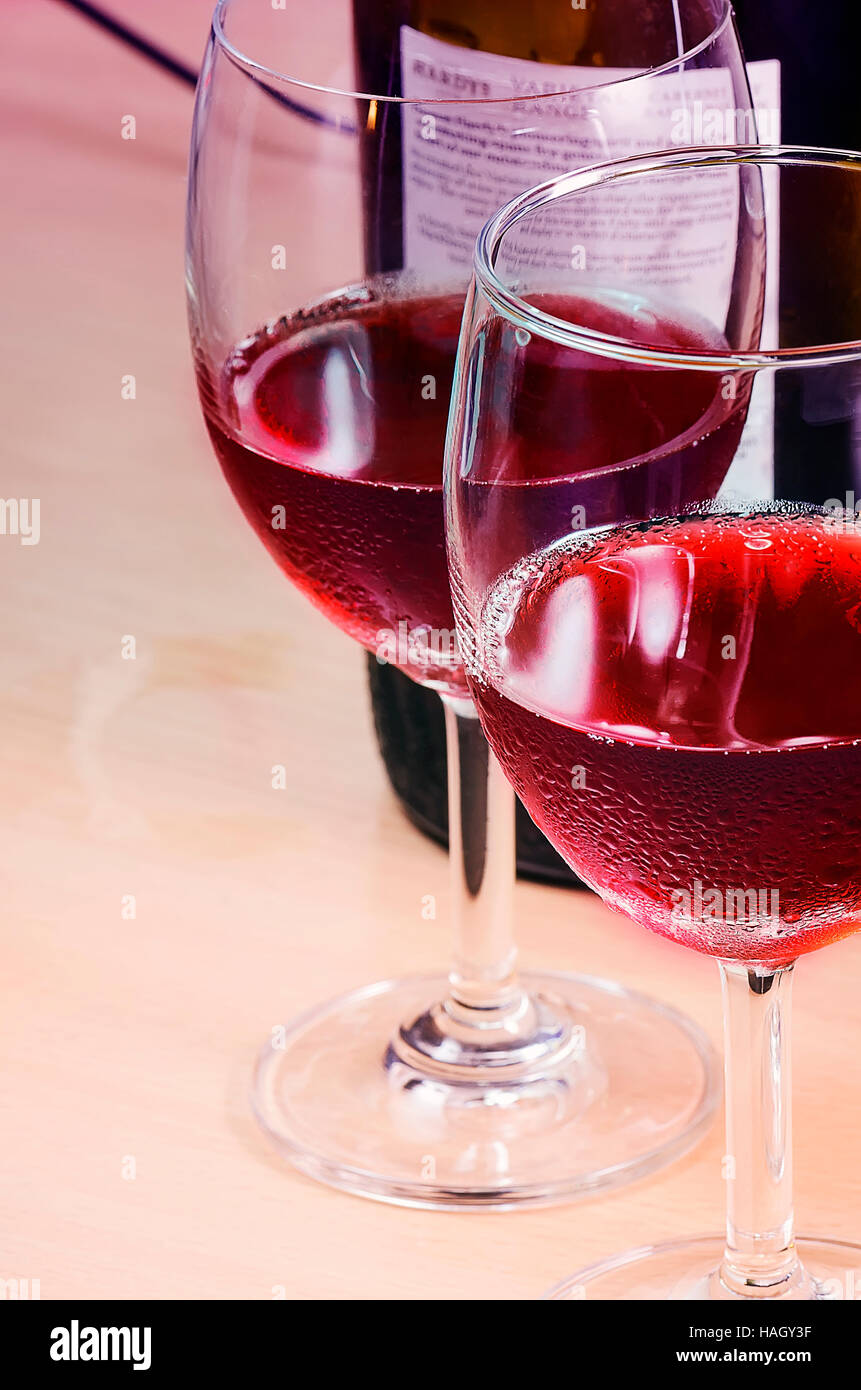 Copa de vino tinto en la mesa,el tono de color rojo. Foto de stock