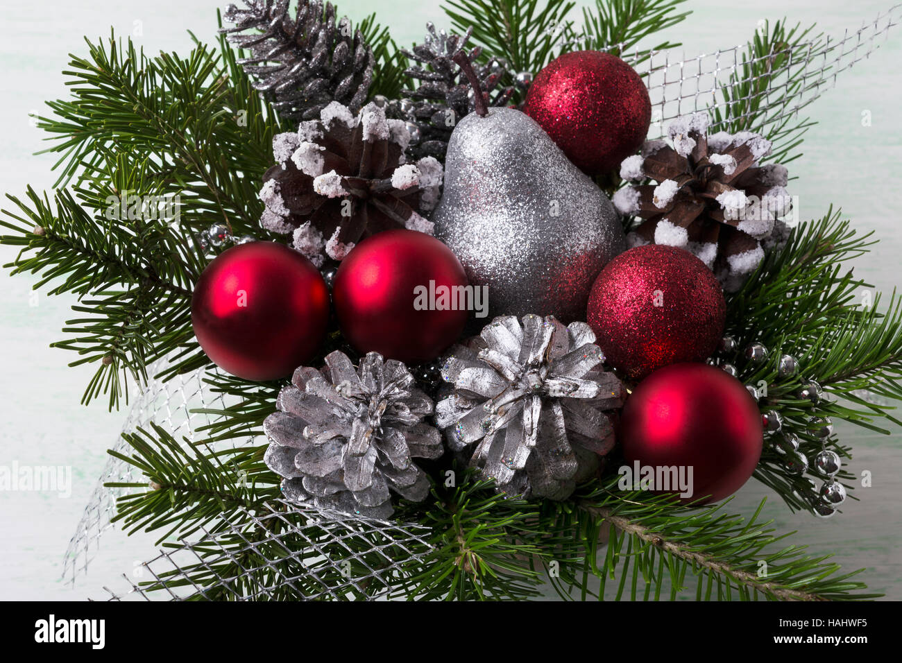 Acuerdo de Navidad con adornos de color rojo, plata y conos de pinos  nevados. Decoración de Navidad con decoración de plata Fotografía de stock  - Alamy