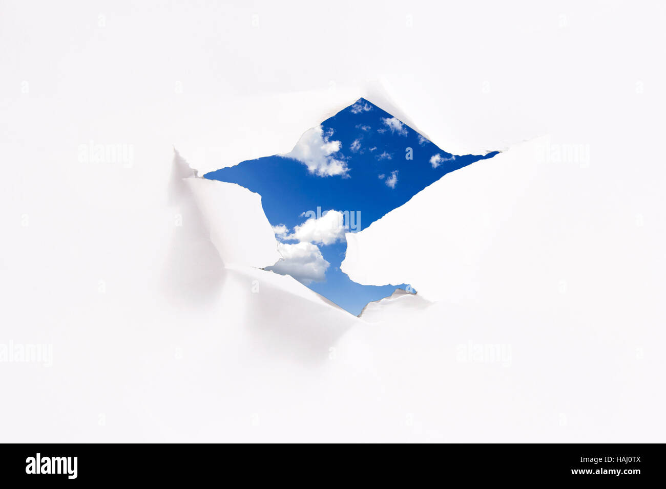 Concepto de libertad: azul cielo detrás del agujero de papel Foto de stock