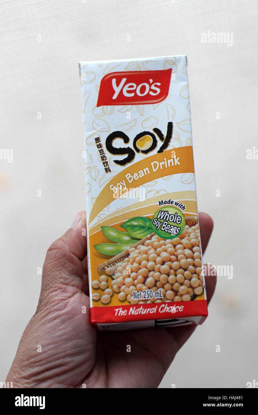 Cerca de un niño Yeo mano sujetando la bebida de soja Foto de stock