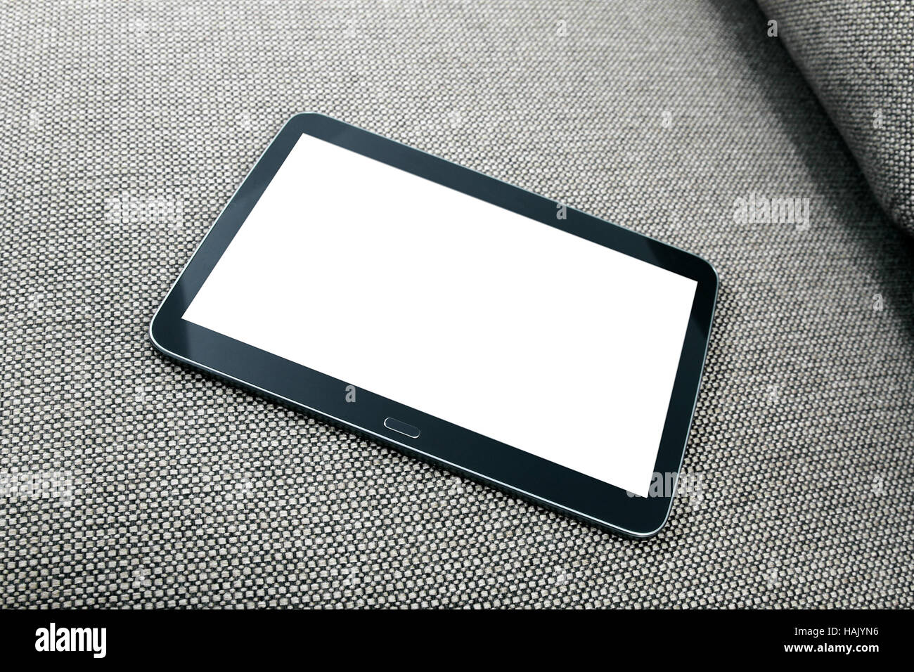 Tableta digital en blanco en el sofá Foto de stock