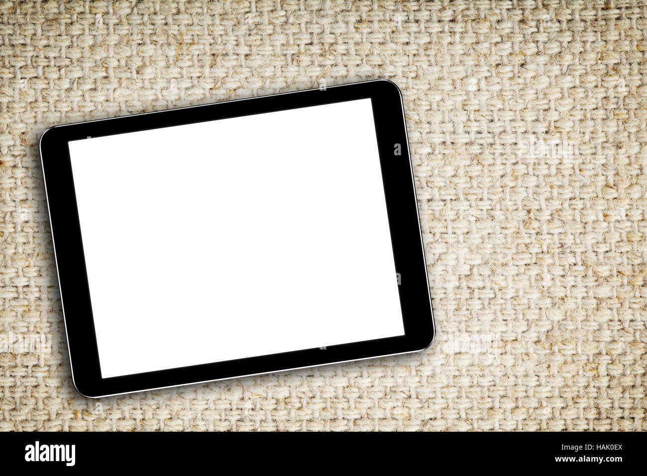 Tableta digital en blanco sobre fondo de tela Foto de stock
