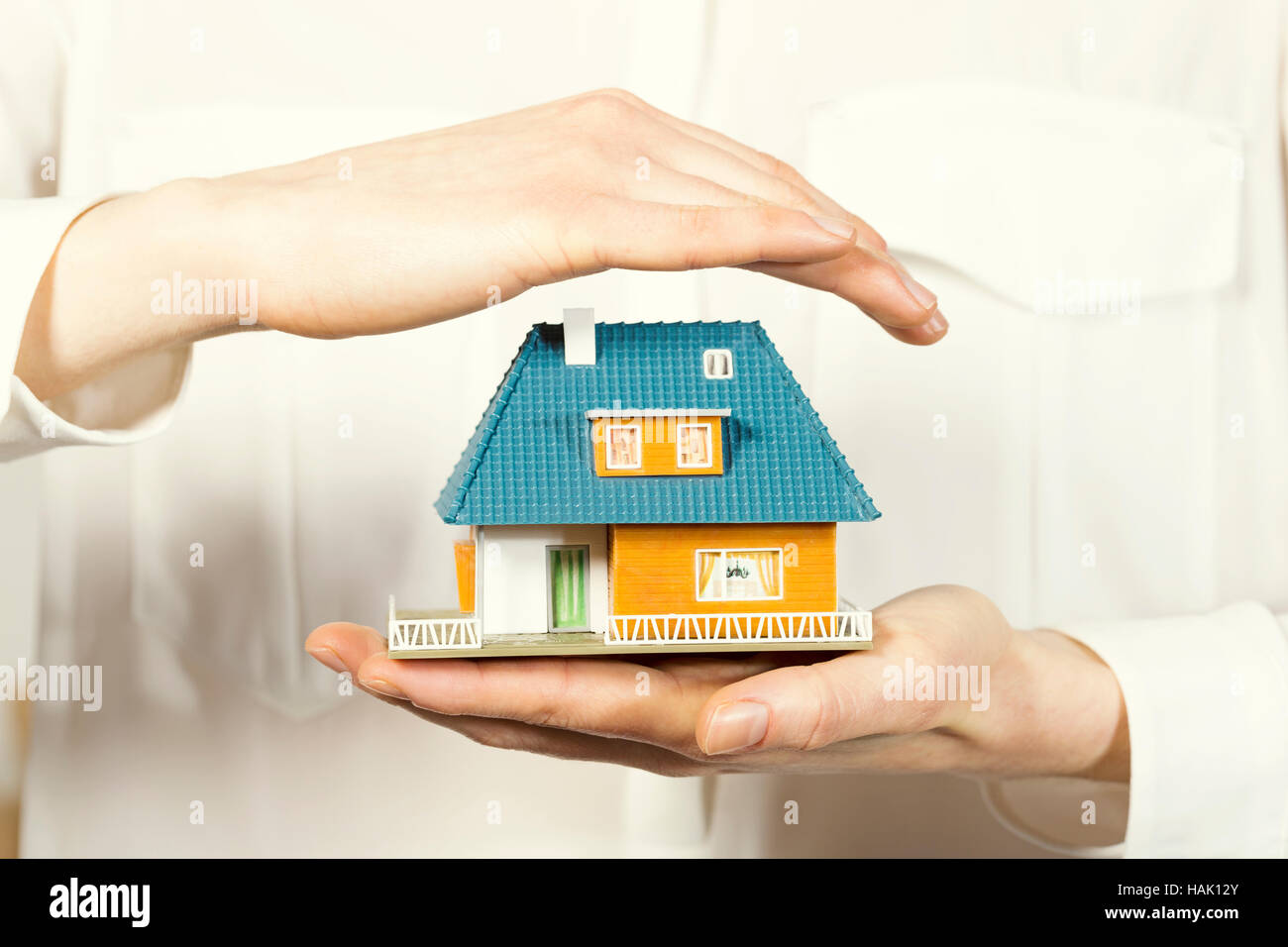 Flotando a mano pequeña casa familiar, seguros de hogar concepto Foto de stock