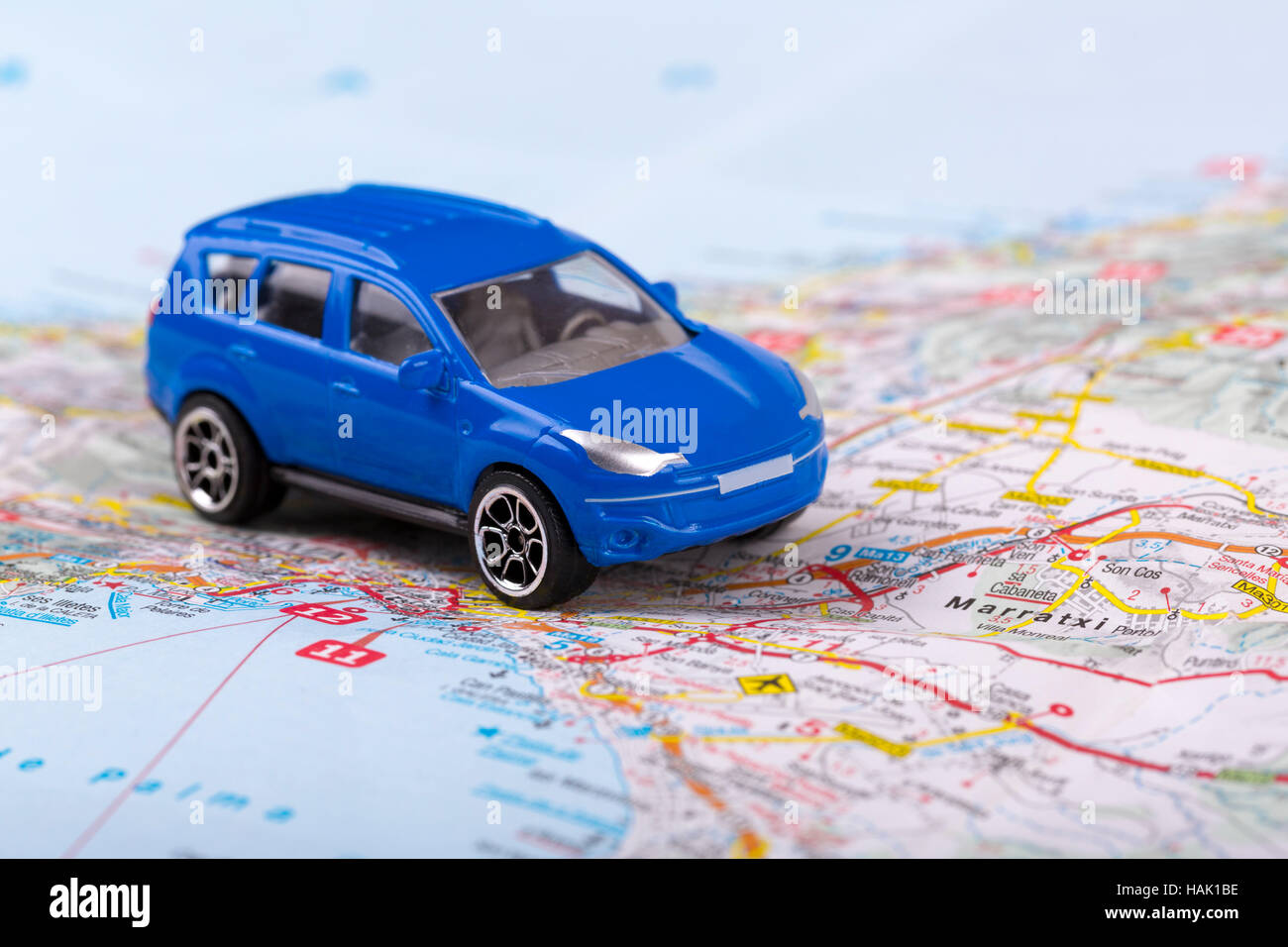 Viaje por carretera, pequeño coche de juguete en el mapa Foto de stock