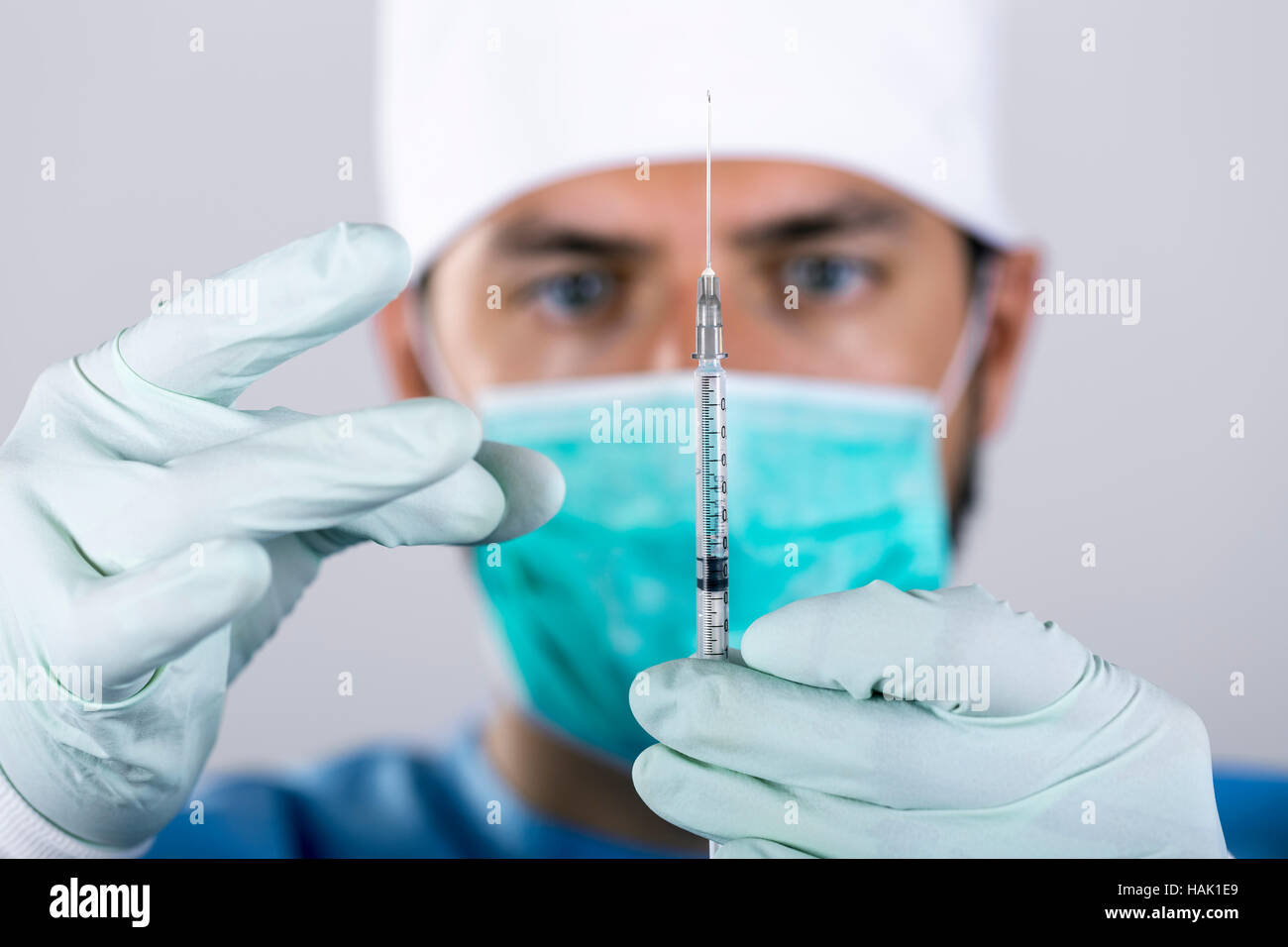 Médico cirujano con jeringa delante de la cara Foto de stock