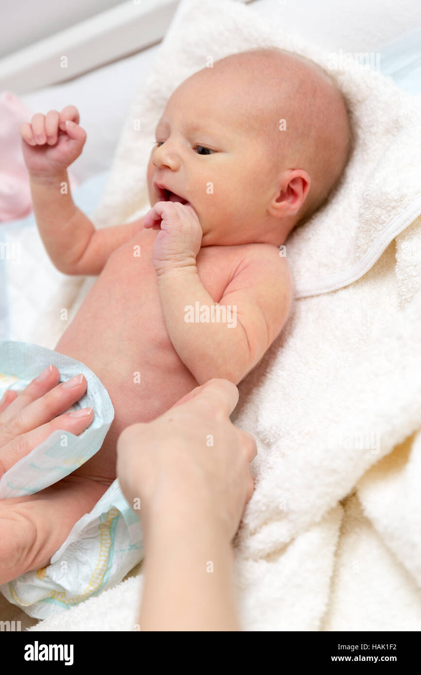 Madre de cambiar pañales para su bebé recién nacido Foto de stock