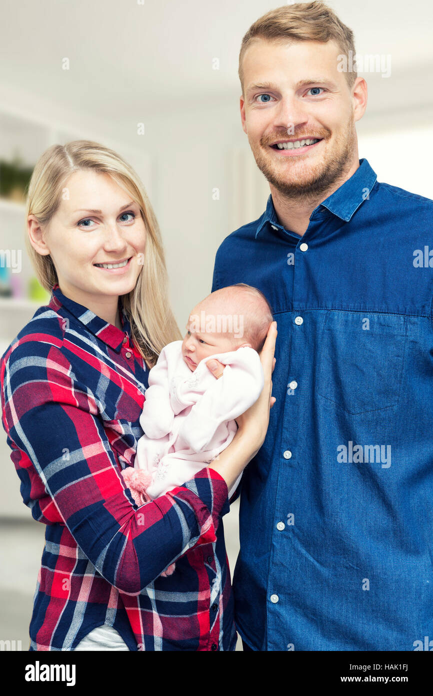 Nueva familia feliz con su bebé recién nacido Foto de stock