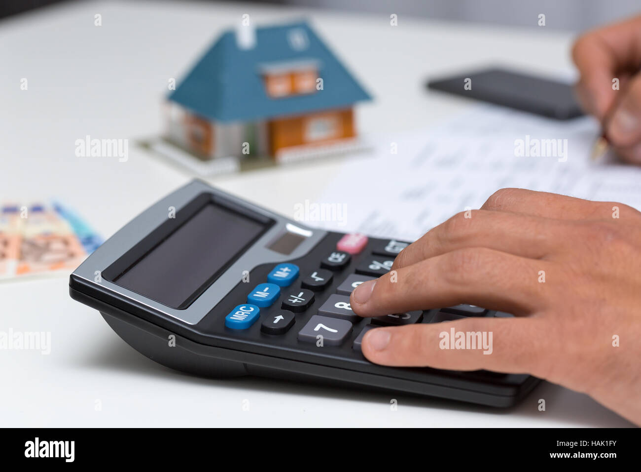 En la calculadora de mano - calcular los gastos del hogar Foto de stock
