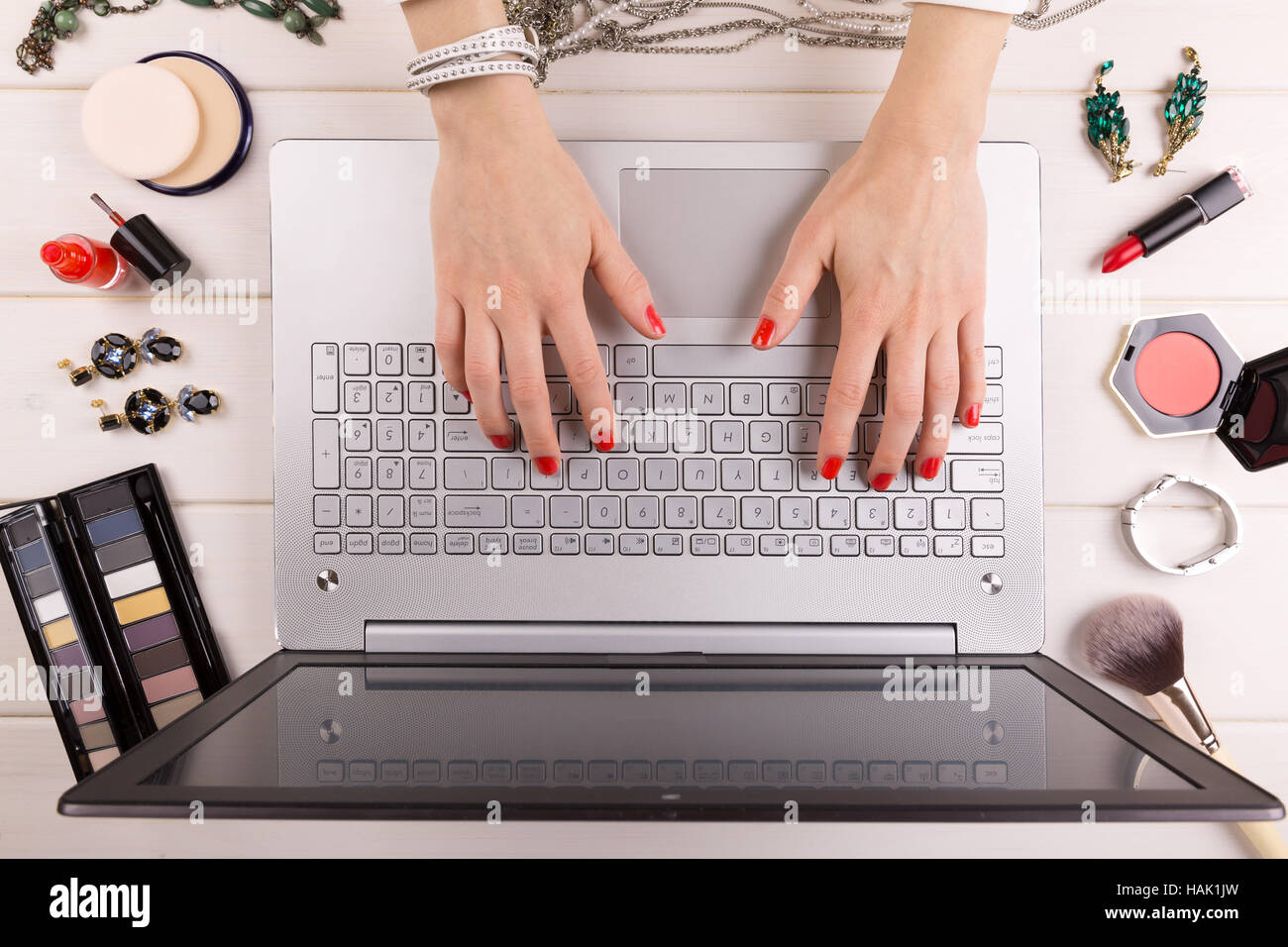 Concepto blogger de moda - Mujer con uñas pulido roja trabajando en el portátil Foto de stock