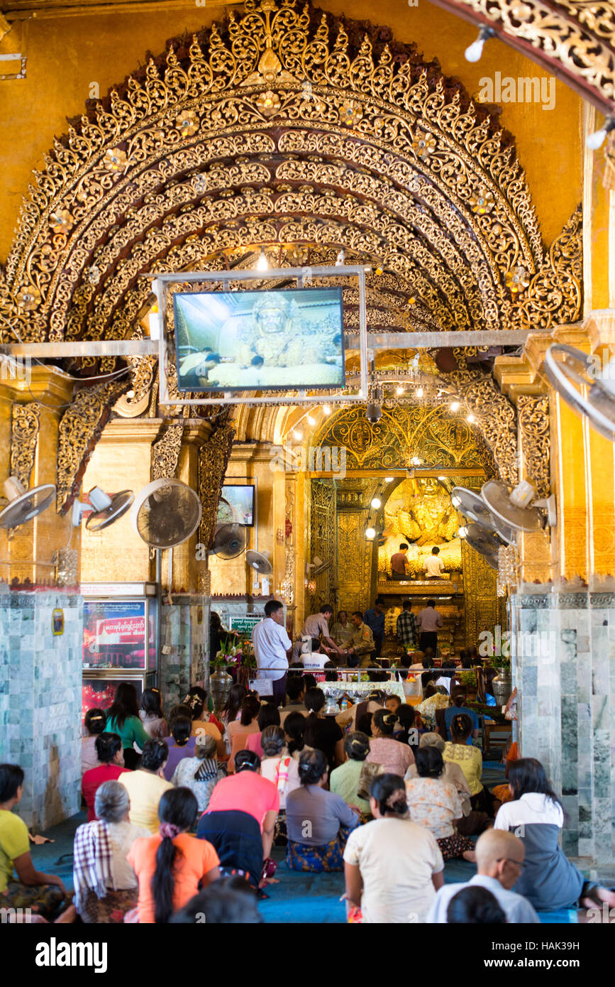MANDALAY, Myanmar - Templo del Buda Mahamuni (también conocido como Pagoda Mahamuni) es un sitio religioso muy venerada en Mandalay. En su centro está la imagen del Buda Mahamuni, que tiene la reputación de ser uno de los cinco personajes originales de Buda hicieron durante su vida. Es recubierta en lámina de oro donados como homenajes por devotos y peregrinos. Foto de stock