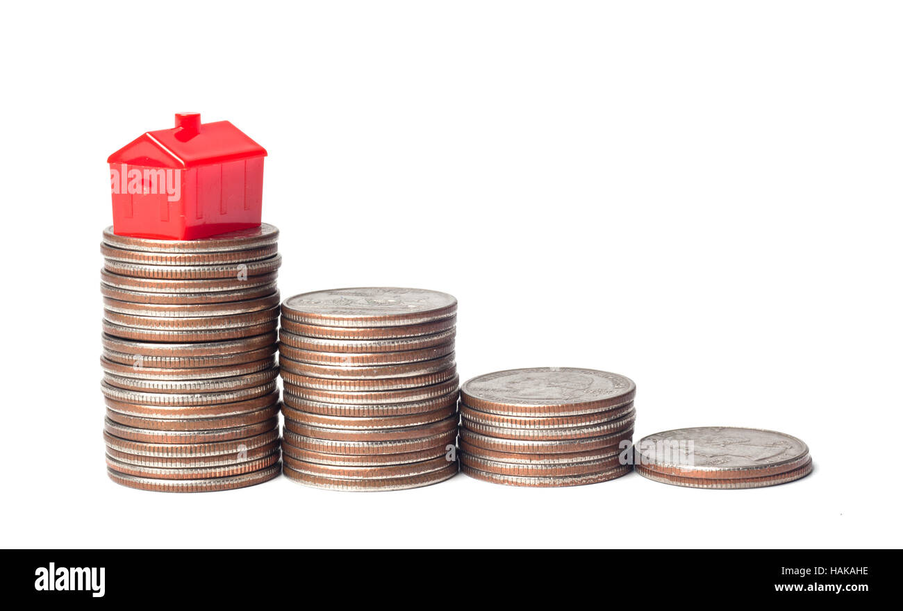 Juguetes Casa y montón de monedas que representan metas financieras de propiedad de la vivienda Foto de stock