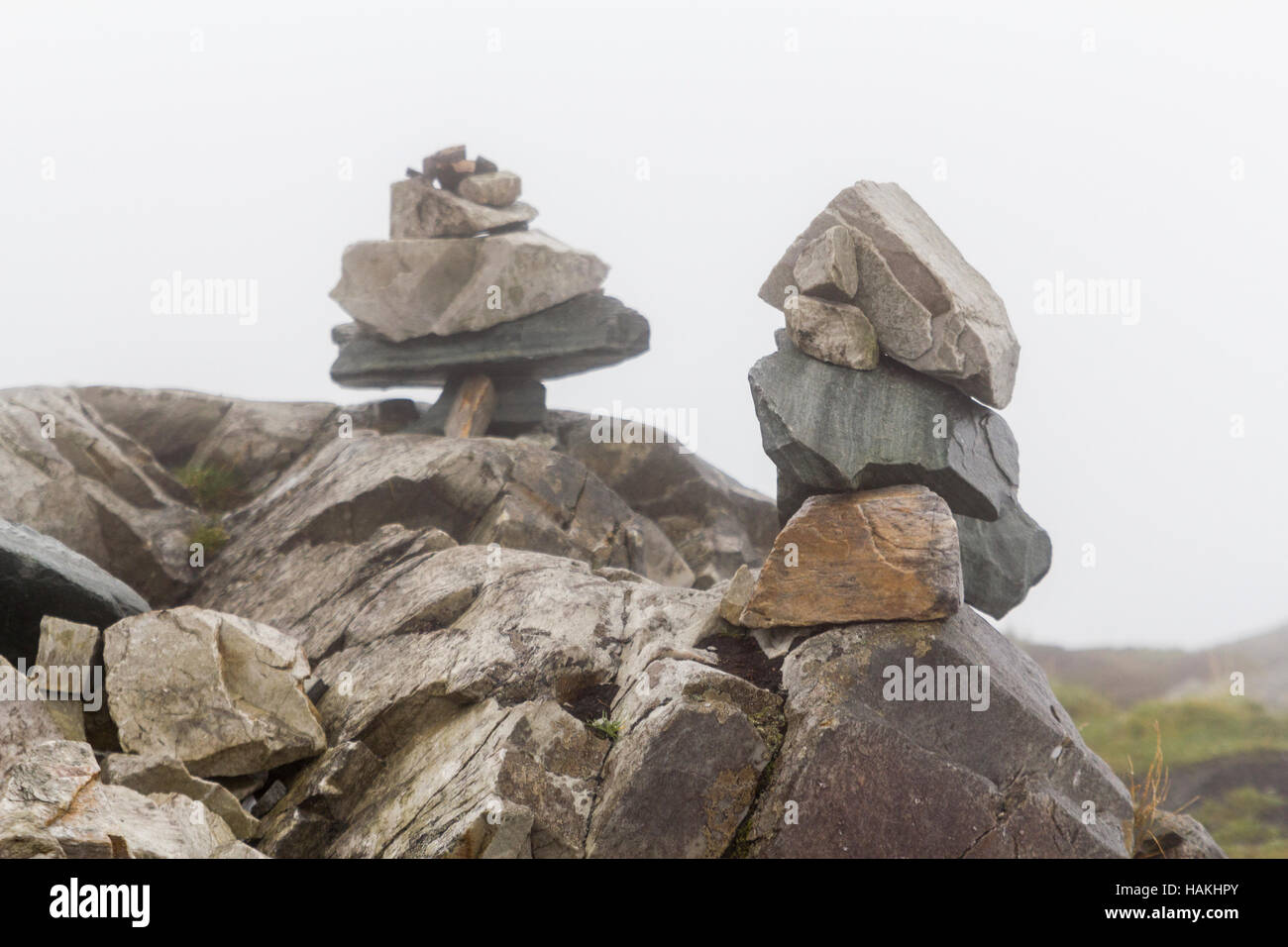 Mojón de piedras apiladas o marcar un camino en la niebla. Foto de stock