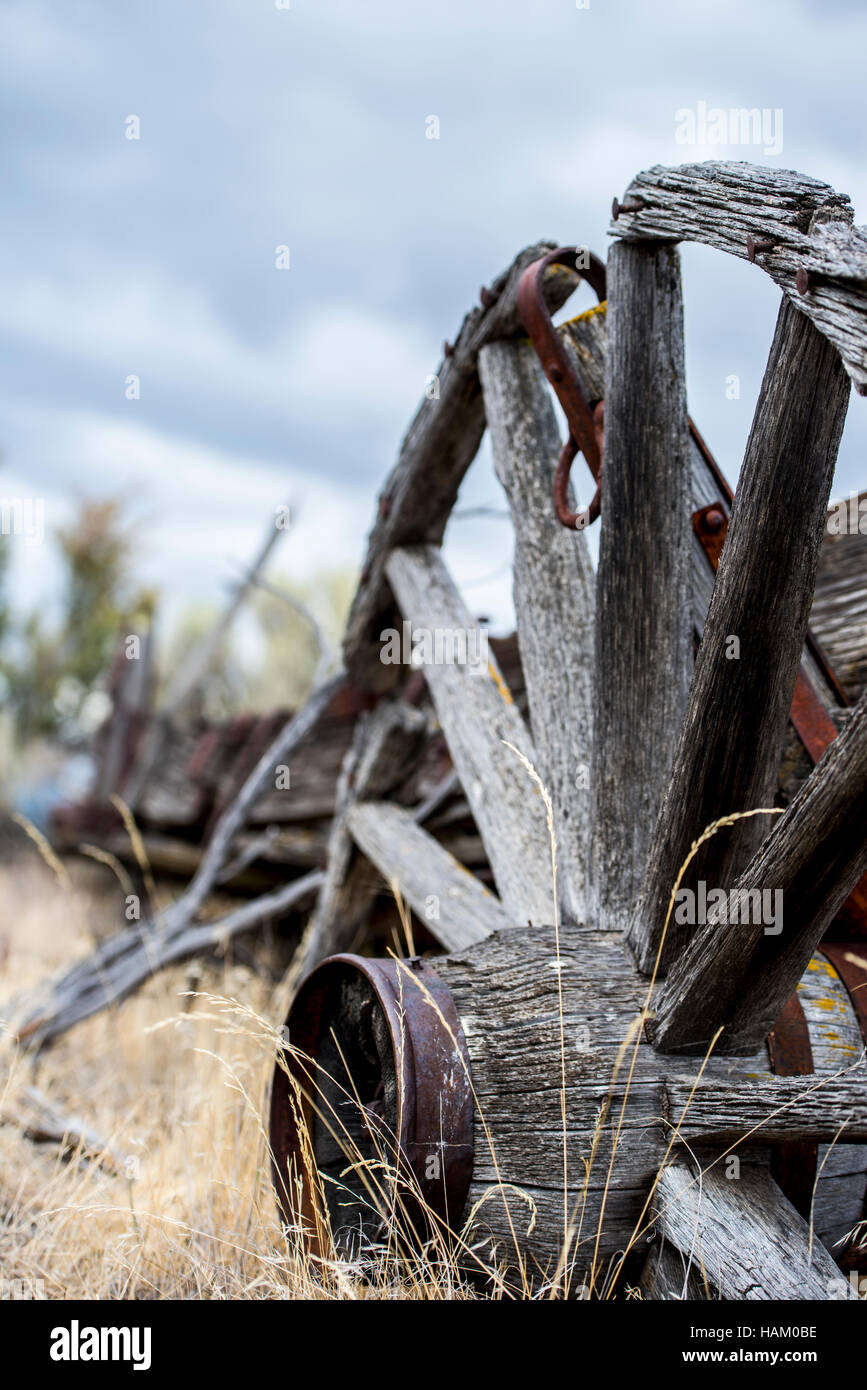 Capeado viejo oeste Wagon Wheel se asienta en pasto seco y la artemisa Foto de stock