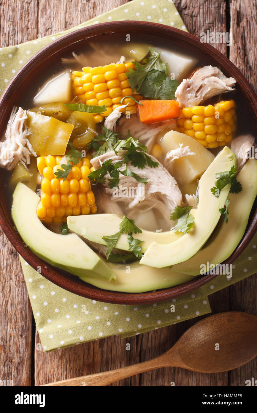 Sabrosa sopa ajiaco con pollo y verduras cerrar en un recipiente sobre la mesa. vista vertical desde arriba Foto de stock