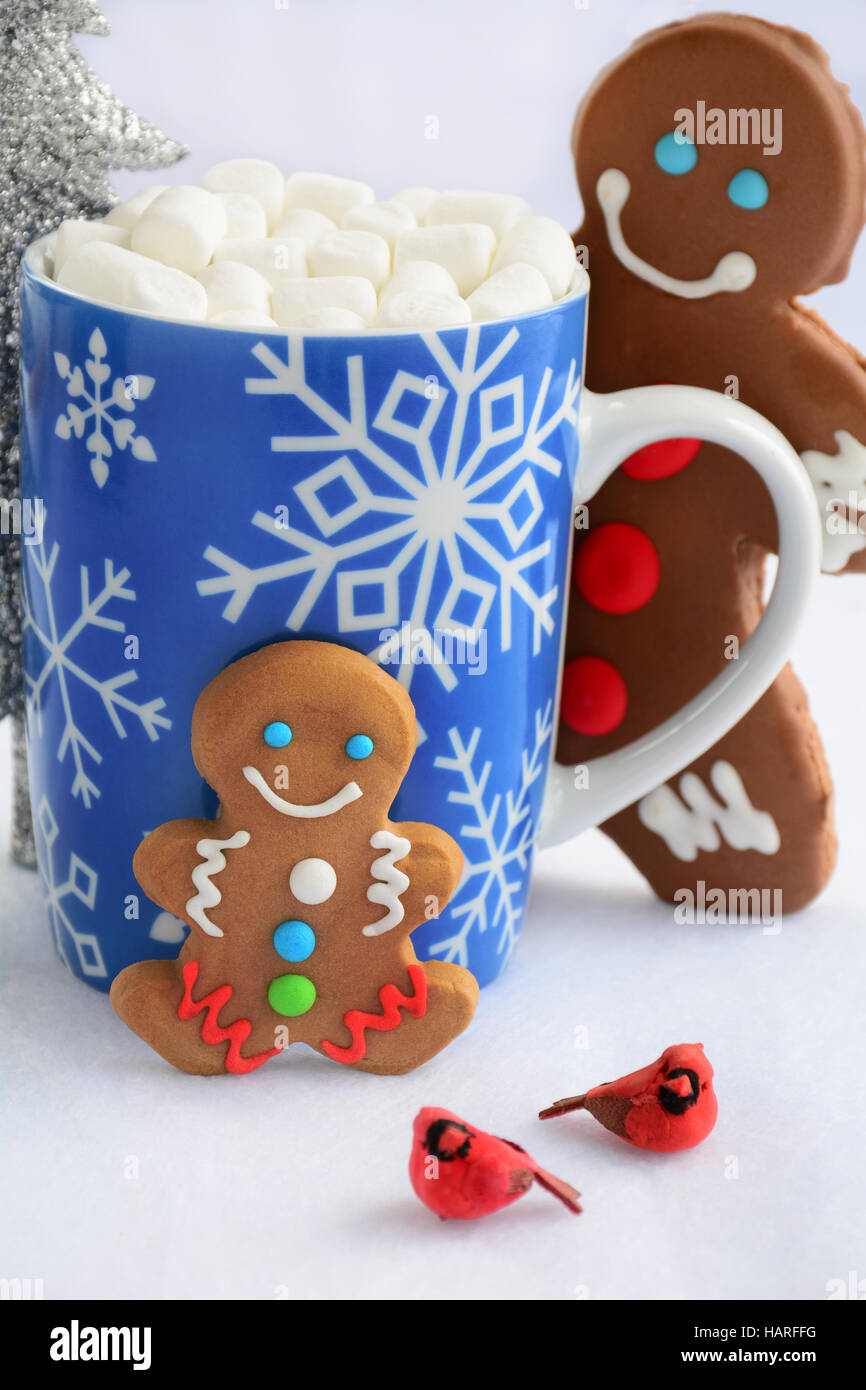 Poco lindo decorado hombres de pan de jengibre con copo de nieve taza de chocolate caliente y mini malvaviscos para tratar de Navidad Foto de stock