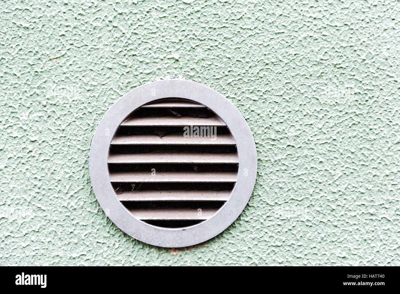 Difusor circular de plástico blanco en la rejilla de ventilación de pared  verde Fotografía de stock - Alamy