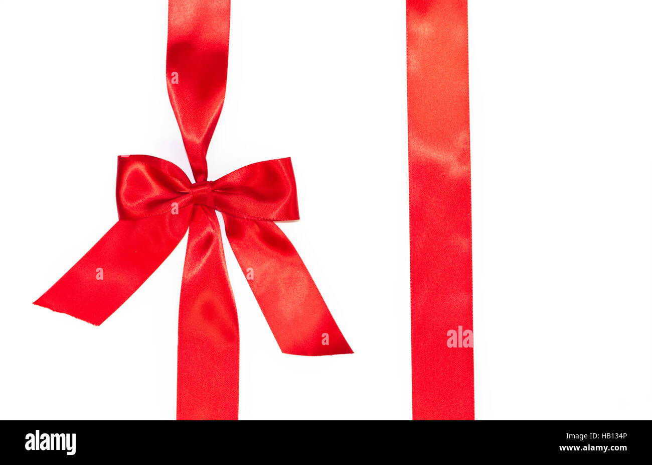 Cintas de regalo roja vertical y lujoso arco aislado sobre fondo blanco. Foto de stock