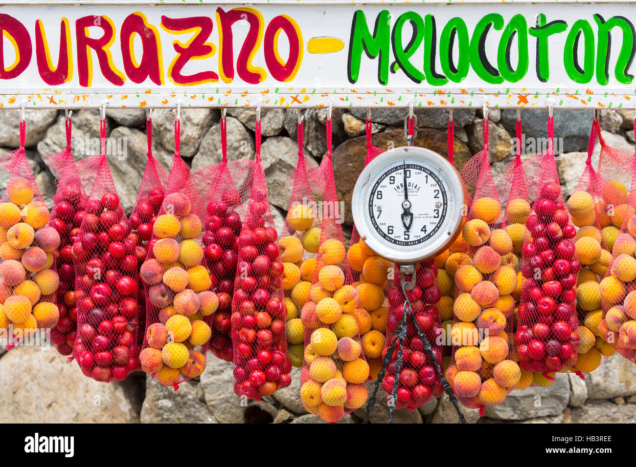 Los albaricoques frescos colgado con escala de peso en el mercado de frutas al aire libre Foto de stock